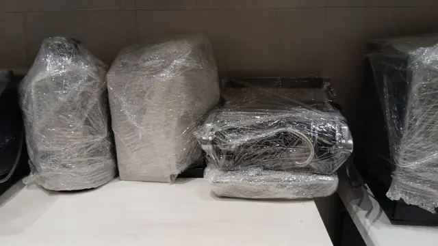 قطع أثاث ومفروشات مغلّفة بفيلم التغليف على رف داخل غرفة