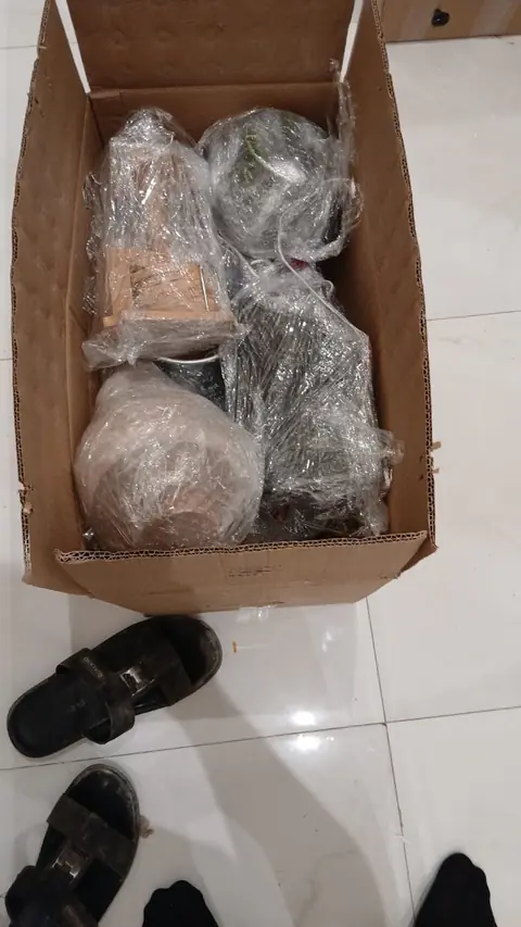 صندوق كرتون فيه أغراض مغلّفة بفيلم التغليف